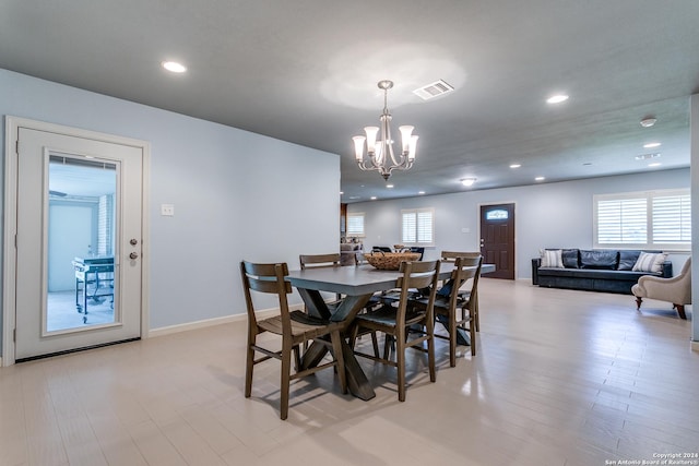 dining space featuring light wood-type flooring and a chandelier