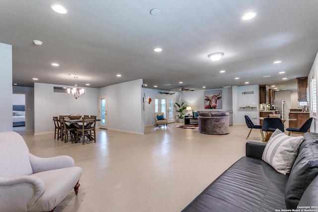 living room with ceiling fan with notable chandelier