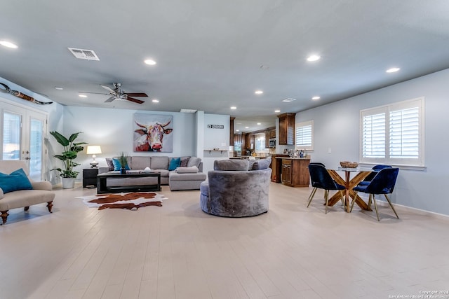 living room with ceiling fan and light hardwood / wood-style flooring