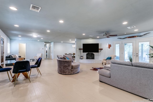 living room featuring ceiling fan, french doors, and light wood-type flooring