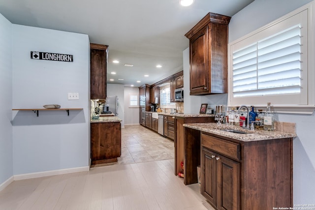 kitchen featuring appliances with stainless steel finishes, dark brown cabinets, and sink