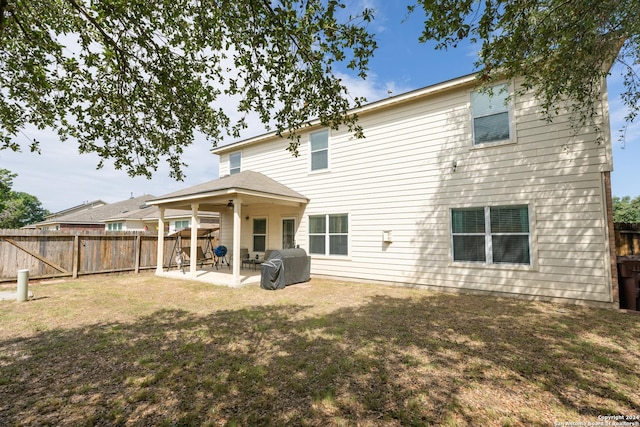 rear view of house featuring a patio area and a yard