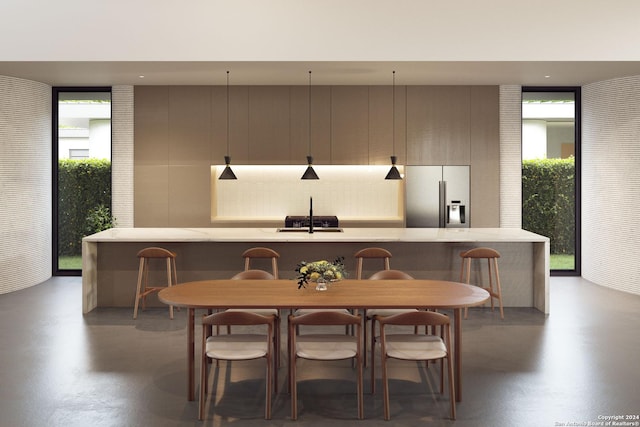 dining area with a wall of windows and finished concrete flooring