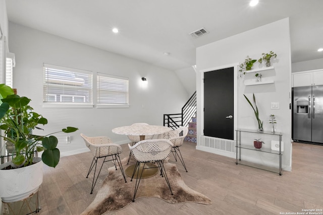 dining space featuring light hardwood / wood-style floors and vaulted ceiling