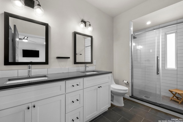 bathroom with a shower with door, vanity, and toilet