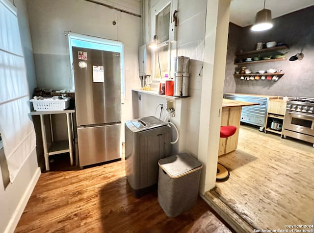 kitchen featuring appliances with stainless steel finishes, hardwood / wood-style floors, and decorative light fixtures