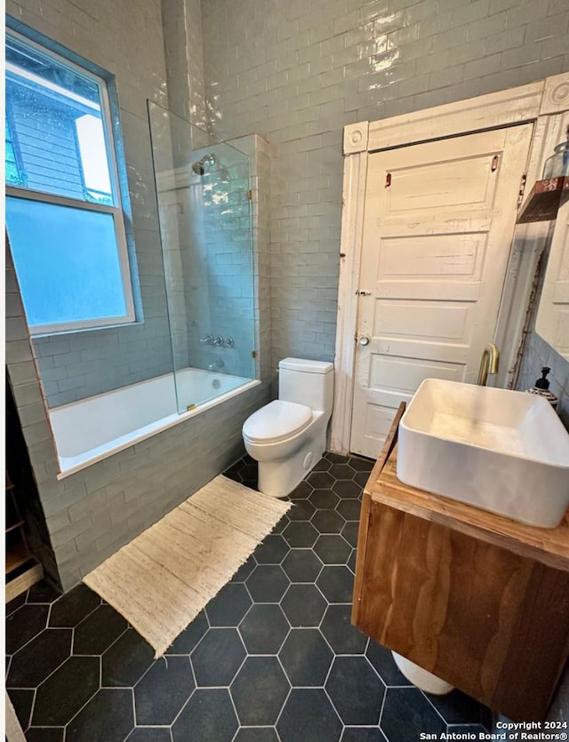 218 Coleman, San Antonio, TX 78208 - bathroom with tile patterned floors, tiled shower / bath, toilet, and vanity