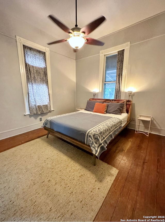 bedroom with dark hardwood / wood-style floors and ceiling fan