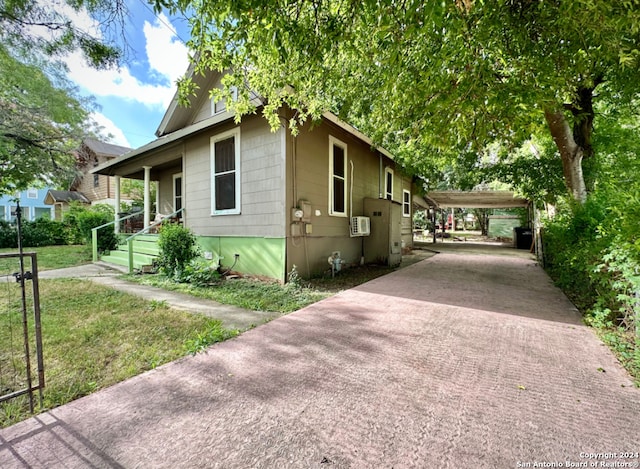 view of side of home featuring a carport and a yard