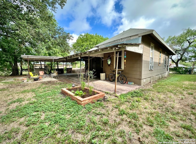 back of house featuring a yard and a patio area