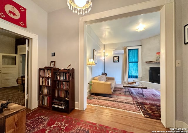 hallway featuring a wall unit AC and dark hardwood / wood-style floors