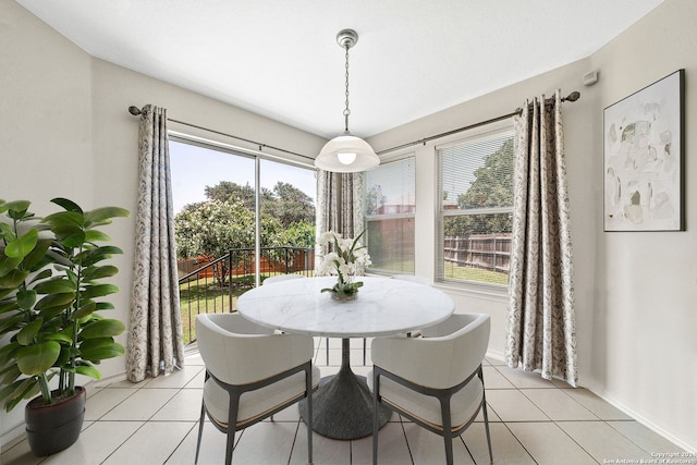 dining area with a wealth of natural light, light tile patterned flooring, and baseboards