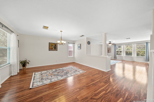 unfurnished room with decorative columns, visible vents, and wood finished floors