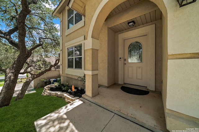 view of exterior entry with a patio area and stucco siding