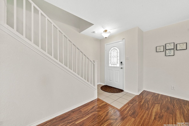 entryway featuring baseboards, stairway, and wood finished floors