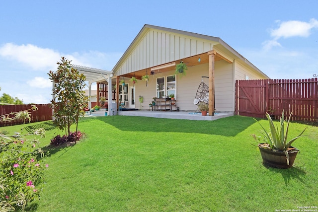 rear view of house featuring a pergola, a patio area, and a lawn