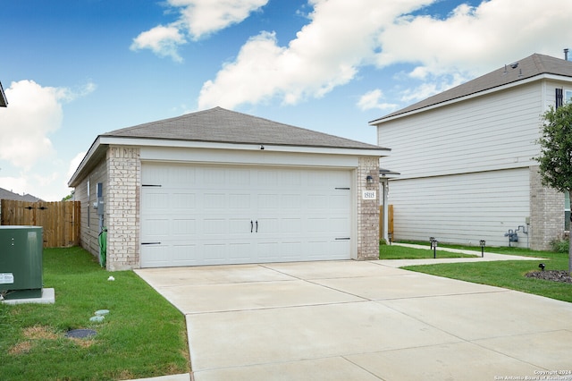 view of front of home with a garage, central AC, and a front yard