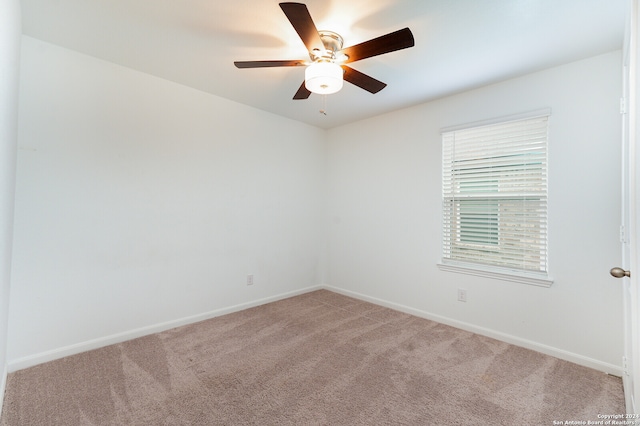 carpeted spare room with ceiling fan