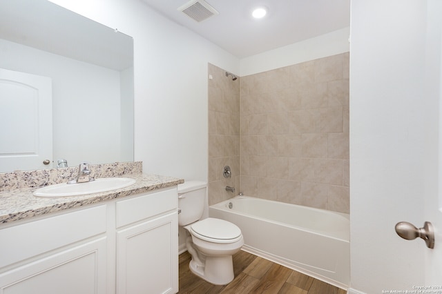 full bathroom with vanity, tiled shower / bath, and toilet