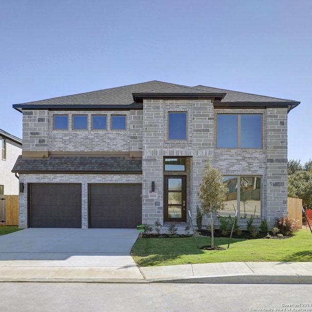 view of front of home with a front yard and a garage