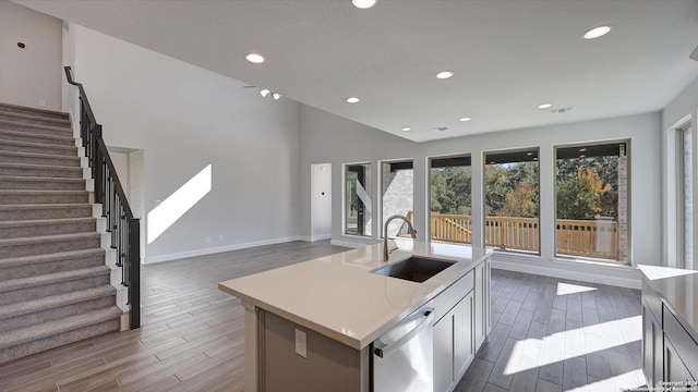 kitchen with sink, white cabinets, an island with sink, and dishwasher