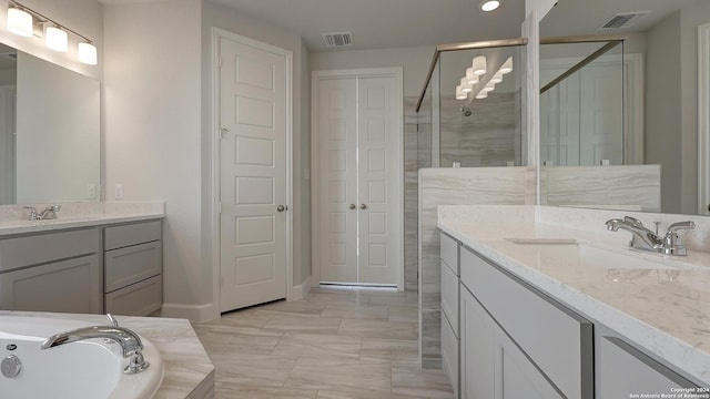 bathroom with vanity and shower with separate bathtub