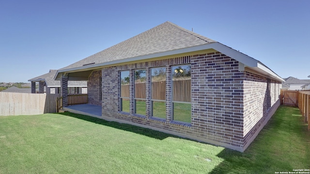 rear view of property with a yard