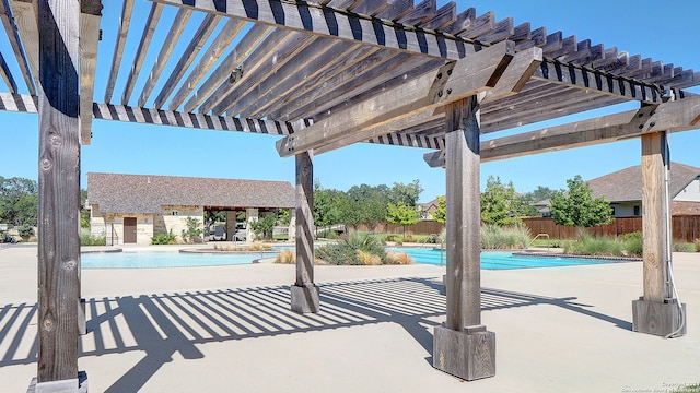 view of patio / terrace featuring a community pool and a pergola