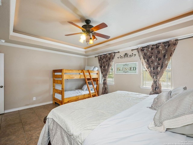 bedroom featuring dark tile patterned floors, a raised ceiling, crown molding, and ceiling fan