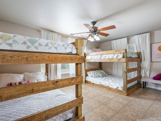 tiled bedroom featuring ceiling fan