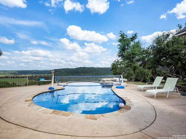 view of swimming pool with a mountain view and a patio area