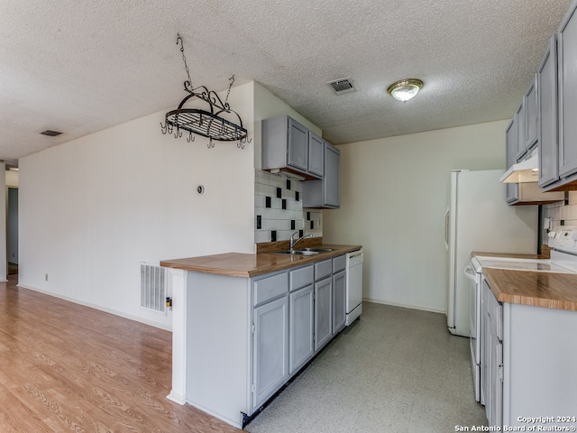 kitchen with range, backsplash, light hardwood / wood-style floors, and a textured ceiling