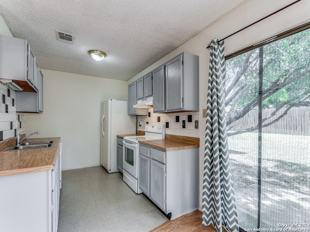 kitchen featuring decorative backsplash, sink, white electric range oven, light tile patterned floors, and gray cabinetry