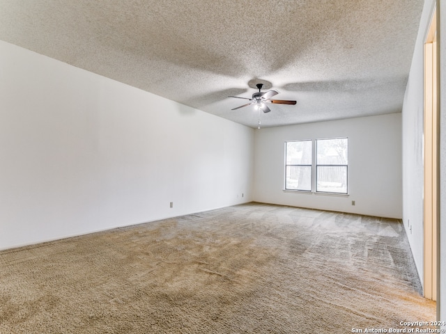 carpeted spare room featuring a textured ceiling and ceiling fan