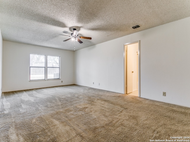 spare room with a textured ceiling, ceiling fan, and carpet flooring