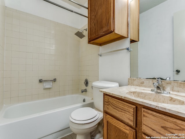 full bathroom with vanity, tiled shower / bath combo, and toilet