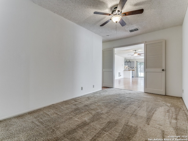 spare room with carpet flooring, a textured ceiling, and ceiling fan