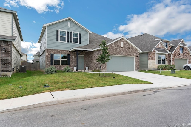 view of front of house with a garage, cooling unit, and a front yard