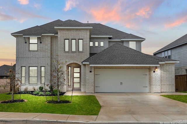 view of front of home with a garage and a yard