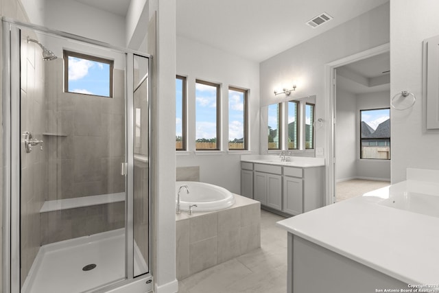 bathroom featuring vanity and independent shower and bath