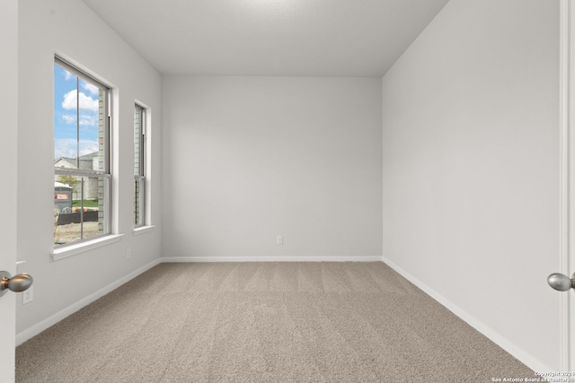 unfurnished room with carpet floors and plenty of natural light