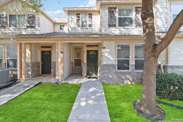 view of front of home featuring central air condition unit and a front lawn