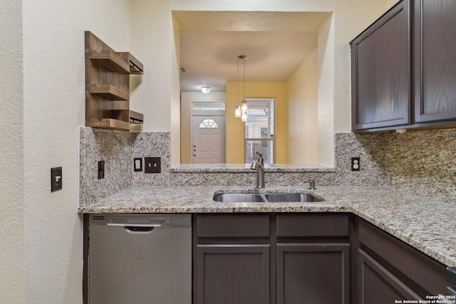 kitchen with light stone counters, stainless steel dishwasher, sink, and tasteful backsplash