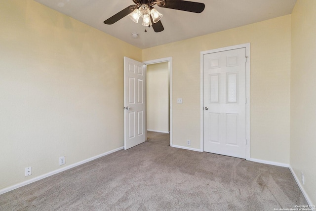 unfurnished bedroom with ceiling fan and light colored carpet