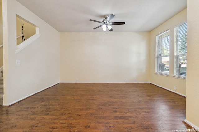 empty room with ceiling fan and dark hardwood / wood-style flooring