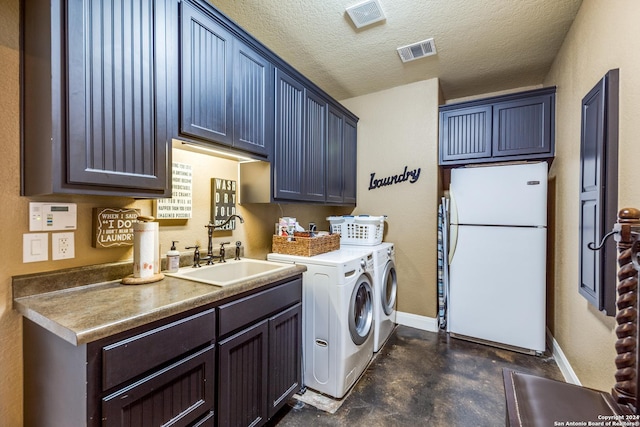 laundry room with a textured ceiling, separate washer and dryer, a sink, visible vents, and cabinet space