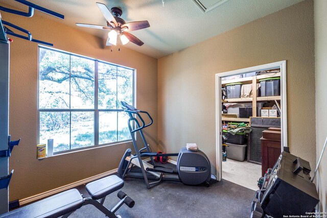 workout room featuring a ceiling fan and baseboards