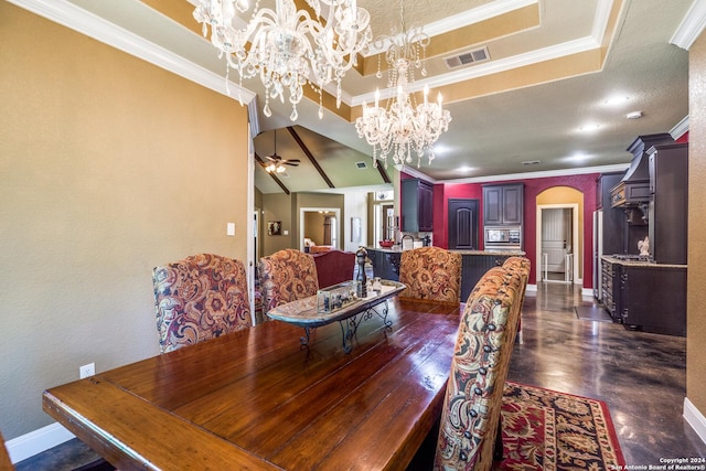 dining space featuring visible vents, arched walkways, a raised ceiling, ornamental molding, and ceiling fan with notable chandelier