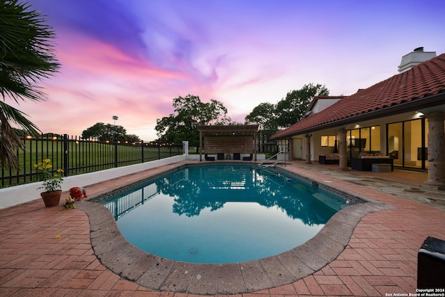 pool at dusk featuring a patio