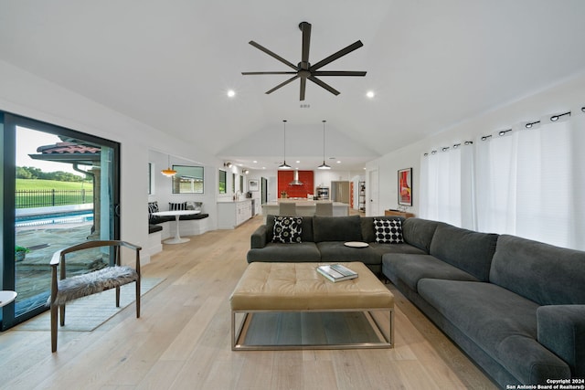 living room featuring light wood-type flooring, vaulted ceiling, and ceiling fan